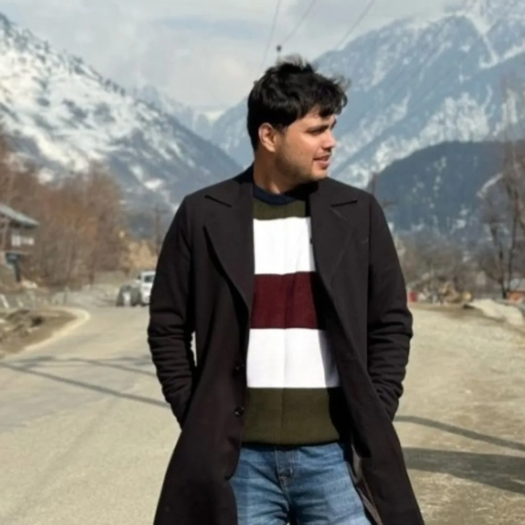 Man wearing a dark overcoat in the mountains
